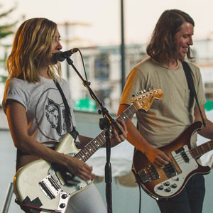 guy and girl playing guitar at concert on stage