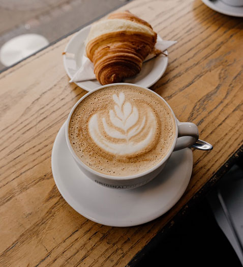 a coffee drink with a croissant